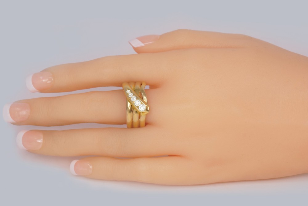 An 18ct yellow gold coiled serpent ring featuring five graduated diamonds set along the head. View X