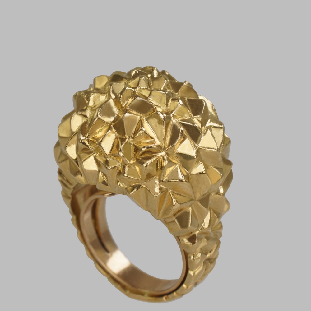 A heavy 18ct yellow gold bombe ring featuring a faceted geometric textured surface with an adjustable inner band.