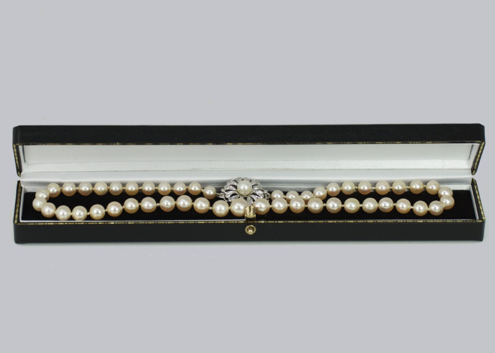 A single strand of cream-coloured pearls hand-knotted on silk thread resting neatly around a neck. View VII