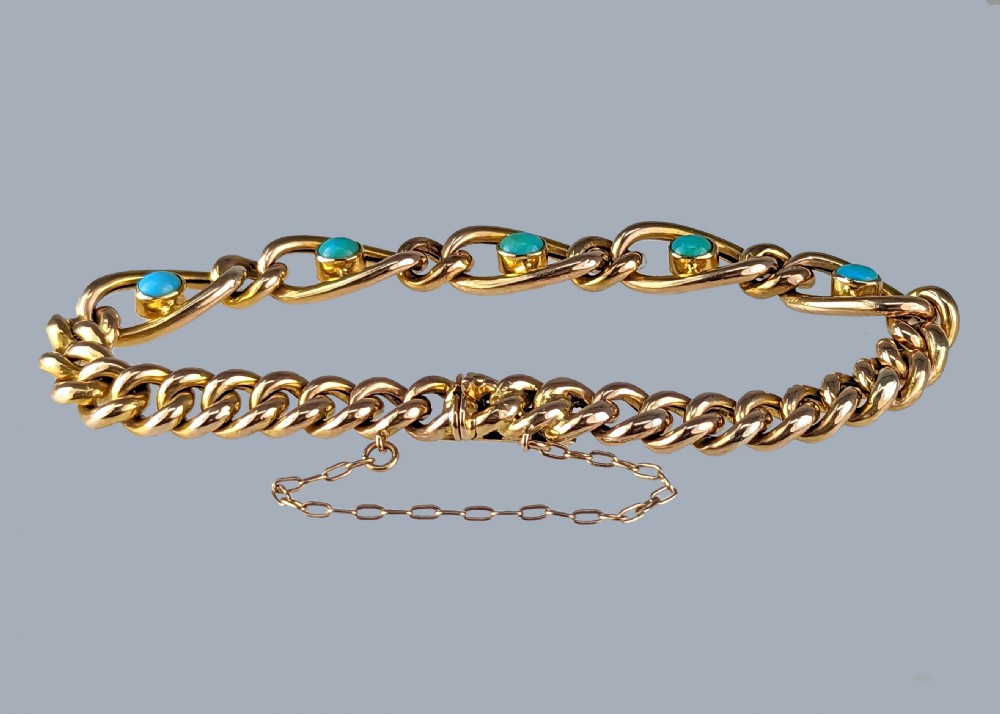 Victorian 9ct yellow gold curb link bracelet featuring oval openwork links set with turquoise cabochons and fitted with a safety chain. View VI