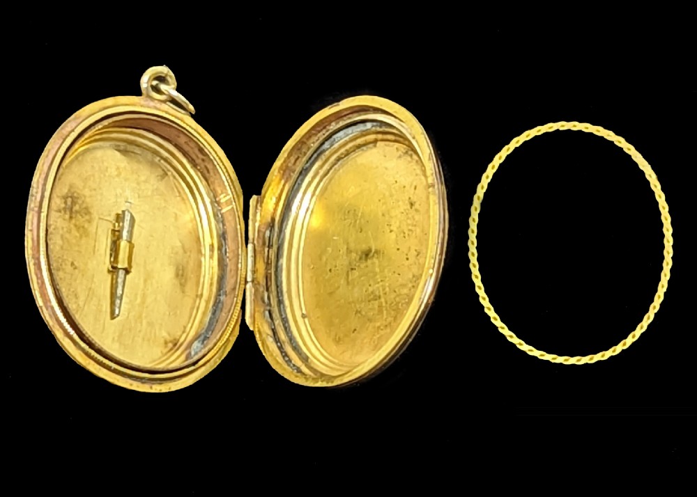 An oval yellow gold Victorian locket featuring a central blue enamel star set with seed pearls and surrounded by an engraved foliate border. View VII