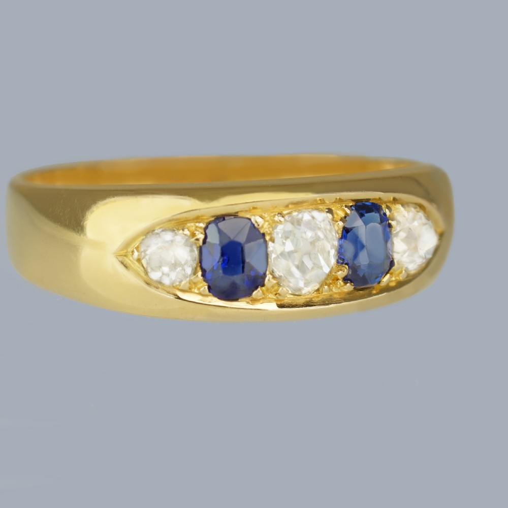 A late Victorian 18ct gold boat ring set horizontally with alternating blue sapphires and white diamonds. View V