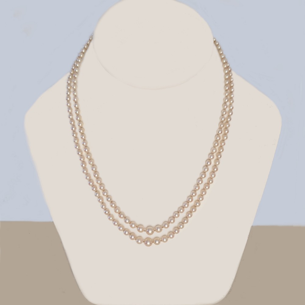 A double strand cream pearl necklace featuring an ornate 9ct gold clasp set with a rectangular step-cut amethyst. View II
