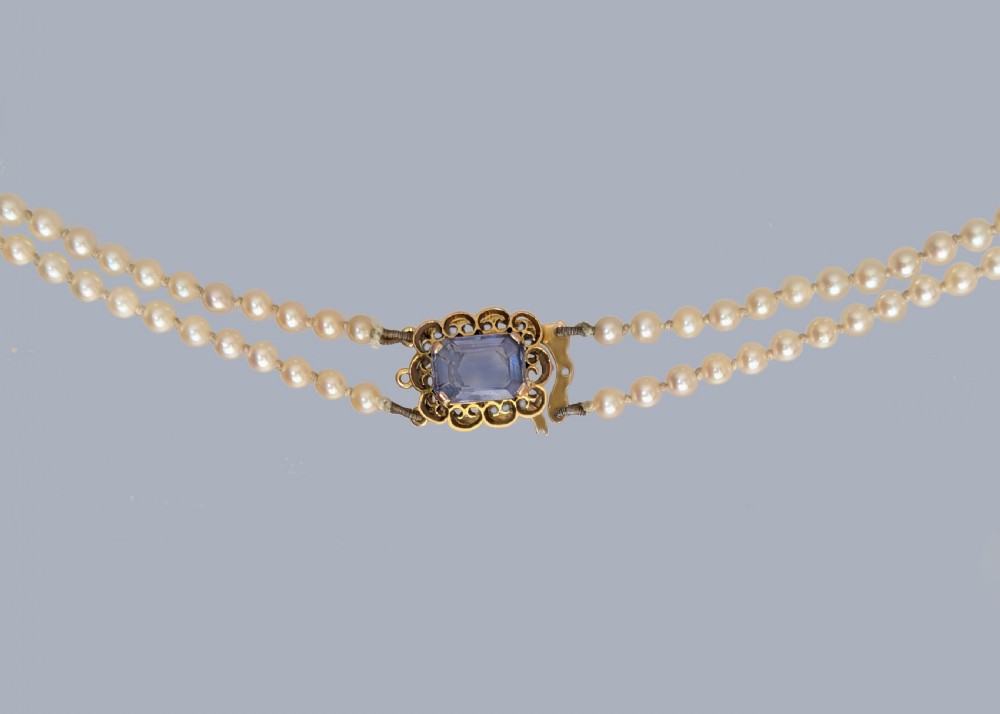 A double strand cream pearl necklace featuring an ornate 9ct gold clasp set with a rectangular step-cut amethyst. View III