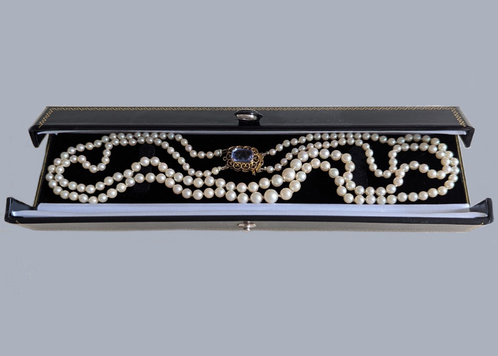 A double strand cream pearl necklace featuring an ornate 9ct gold clasp set with a rectangular step-cut amethyst. View V
