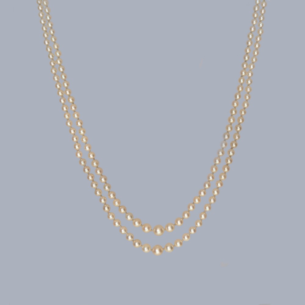 A double strand cream pearl necklace featuring an ornate 9ct gold clasp set with a rectangular step-cut amethyst. View VI