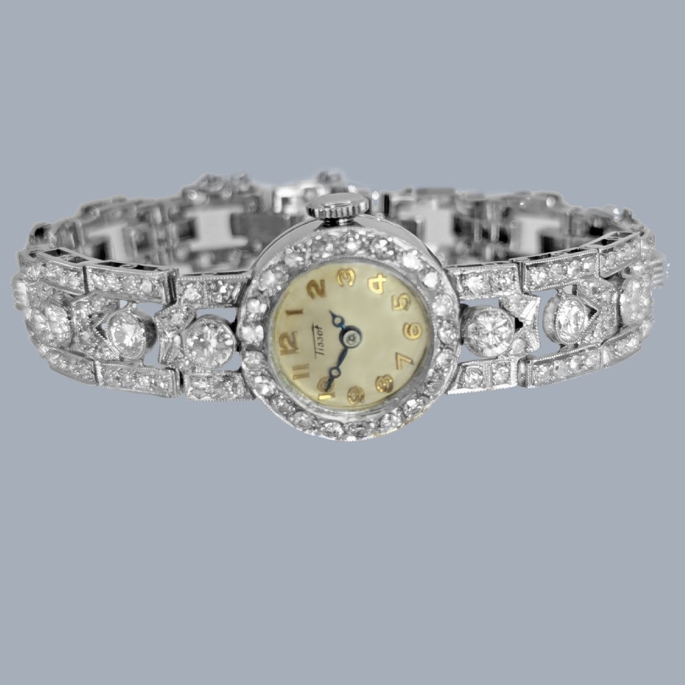 A mid-century Tissot ladies wristwatch featuring a circular cream dial with gold-tone Arabic numerals, set within a platinum bezel and articulated bracelet fully encrusted with round diamonds. View IV
