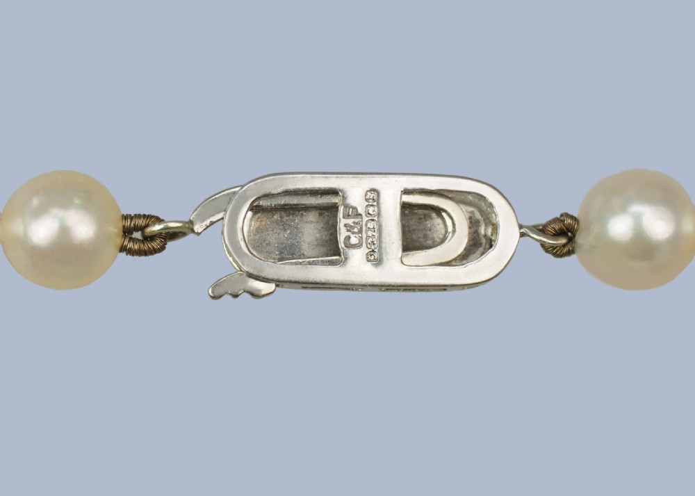 A continuous fifty-inch strand of uniform cream cultured pearls with a rectangular nine-carat gold clasp inset with small pearls. View III