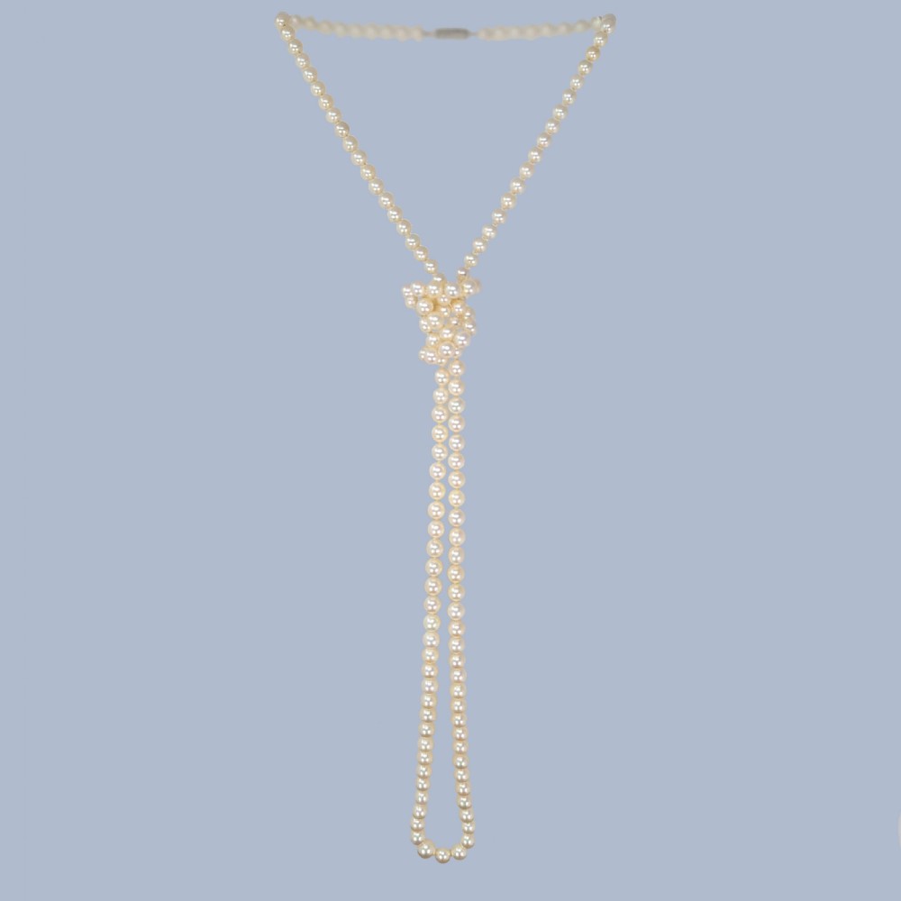 A continuous fifty-inch strand of uniform cream cultured pearls with a rectangular nine-carat gold clasp inset with small pearls. View IV