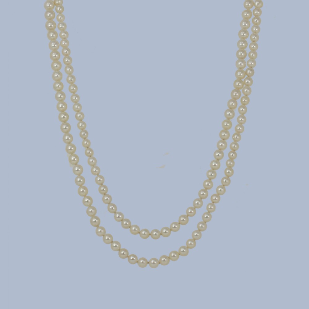 A continuous fifty-inch strand of uniform cream cultured pearls with a rectangular nine-carat gold clasp inset with small pearls. View V