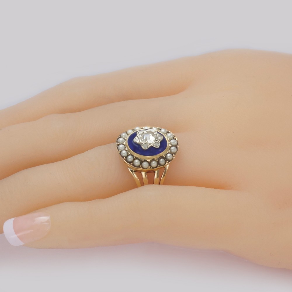 An antique Georgian gold ring featuring a central rose-cut diamond star motif set over cobalt blue glass, surrounded by a border of seed pearls and finished with a split shank band. View IV