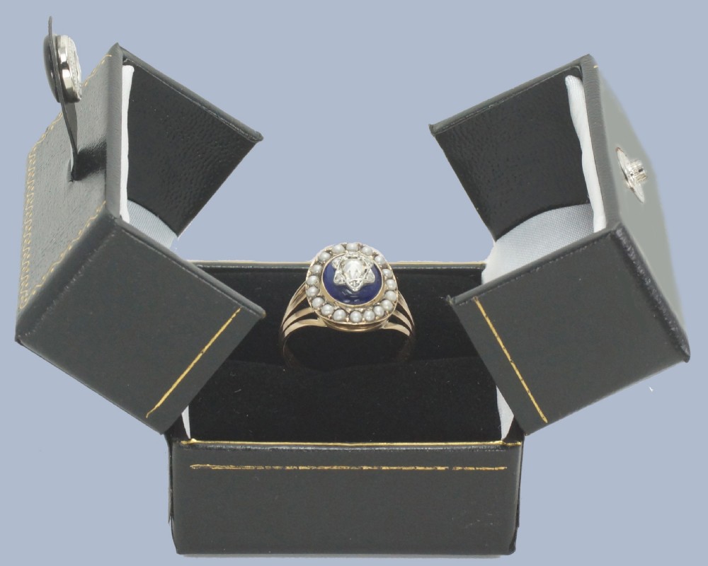 An antique Georgian gold ring featuring a central rose-cut diamond star motif set over cobalt blue glass, surrounded by a border of seed pearls and finished with a split shank band. View XI