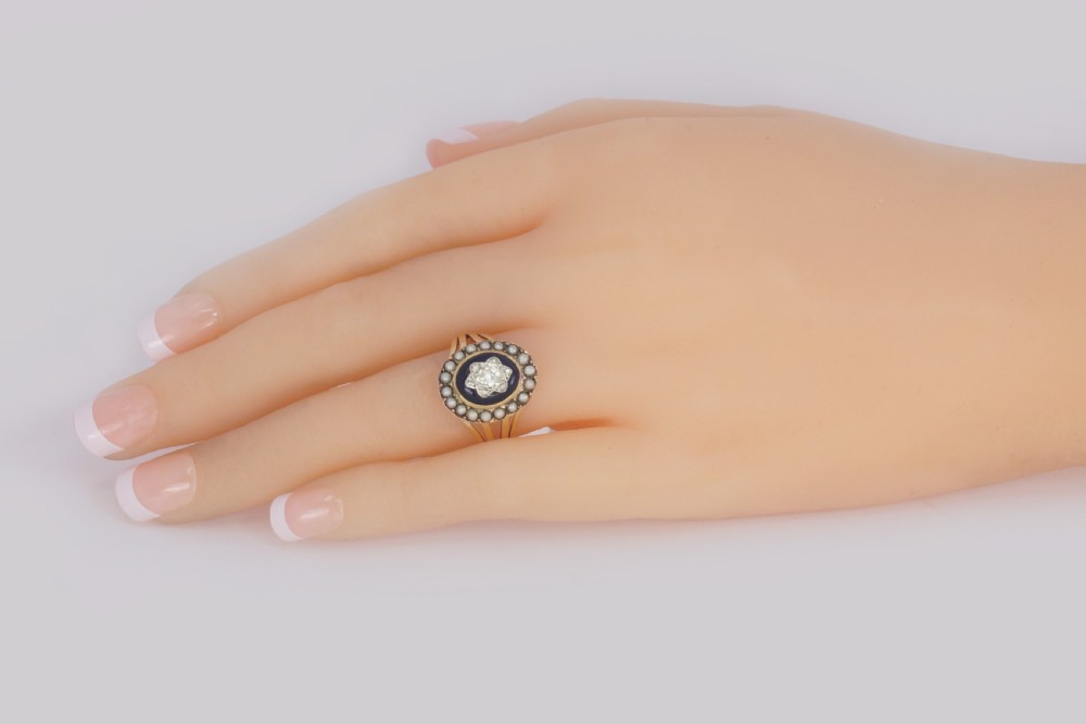 An antique Georgian gold ring featuring a central rose-cut diamond star motif set over cobalt blue glass, surrounded by a border of seed pearls and finished with a split shank band. View XII