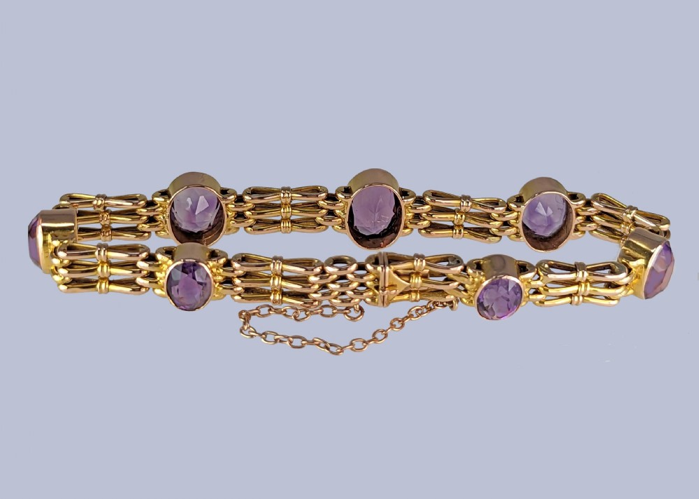 Victorian 9ct gold gate link bracelet set with six oval faceted purple amethyst gemstones and fitted with a safety chain. View VII