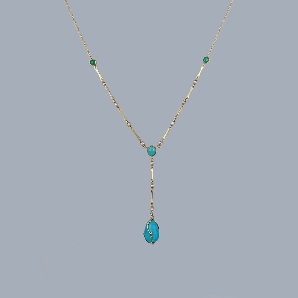 An Arts and Crafts 15ct gold necklace featuring elongated bar links set with small pearls, leading to a central turquoise cabochon and a dangling caged turquoise drop pendant. View VI