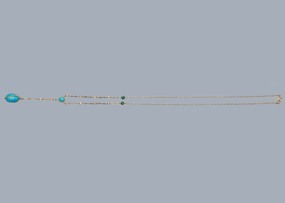 An Arts and Crafts 15ct gold necklace featuring elongated bar links set with small pearls, leading to a central turquoise cabochon and a dangling caged turquoise drop pendant. View VIII