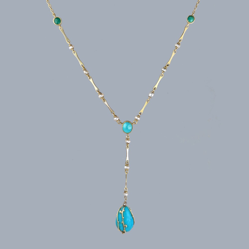 An Arts and Crafts 15ct gold necklace featuring elongated bar links set with small pearls, leading to a central turquoise cabochon and a dangling caged turquoise drop pendant. View XII