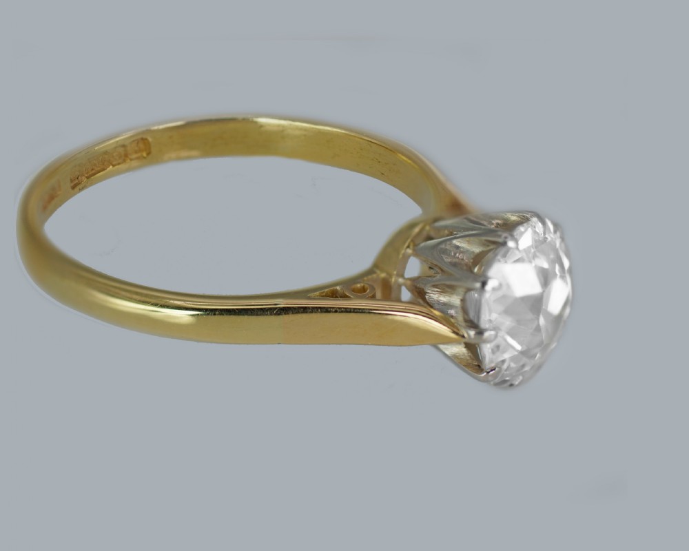 A vintage 18ct yellow gold solitaire ring featuring a 1.3-carat old cushion-cut diamond held in white metal claw settings. View VI