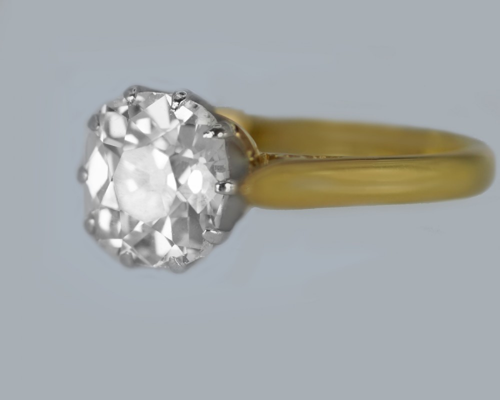 A vintage 18ct yellow gold solitaire ring featuring a 1.3-carat old cushion-cut diamond held in white metal claw settings. View VII