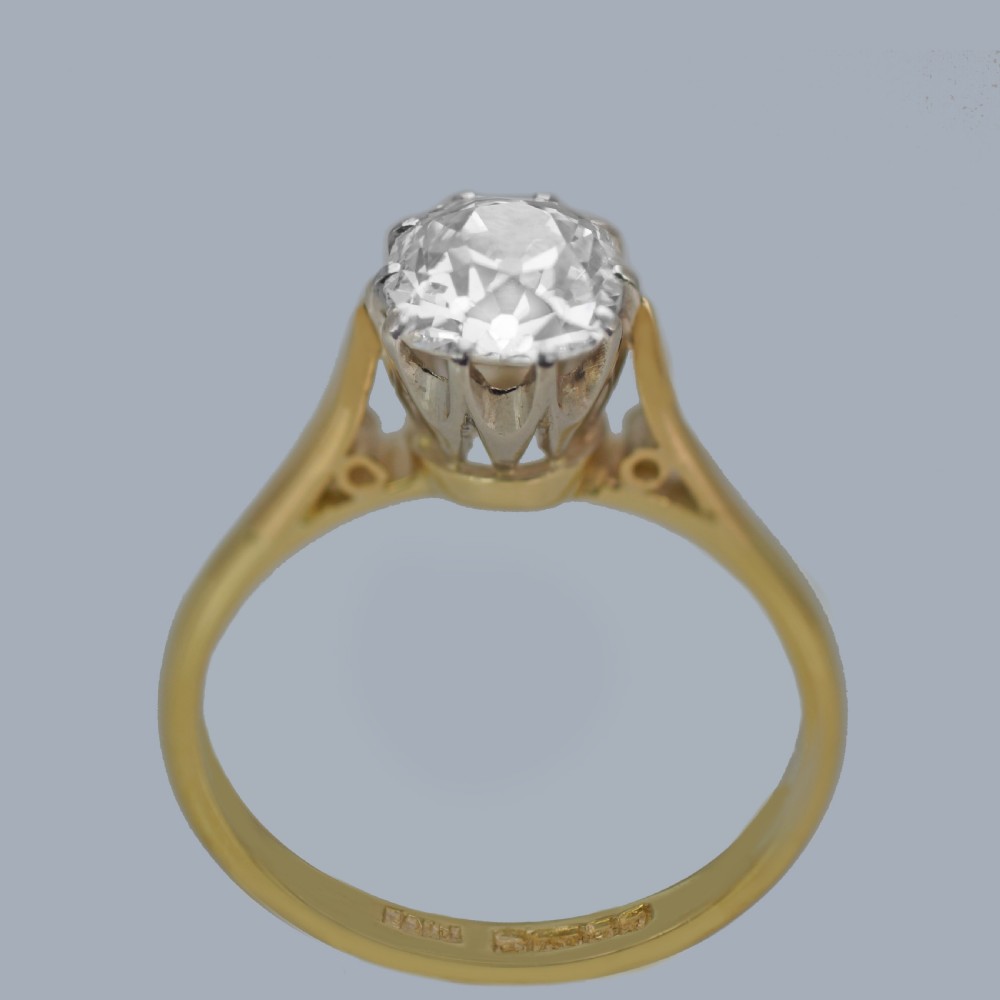 A vintage 18ct yellow gold solitaire ring featuring a 1.3-carat old cushion-cut diamond held in white metal claw settings. View VIII