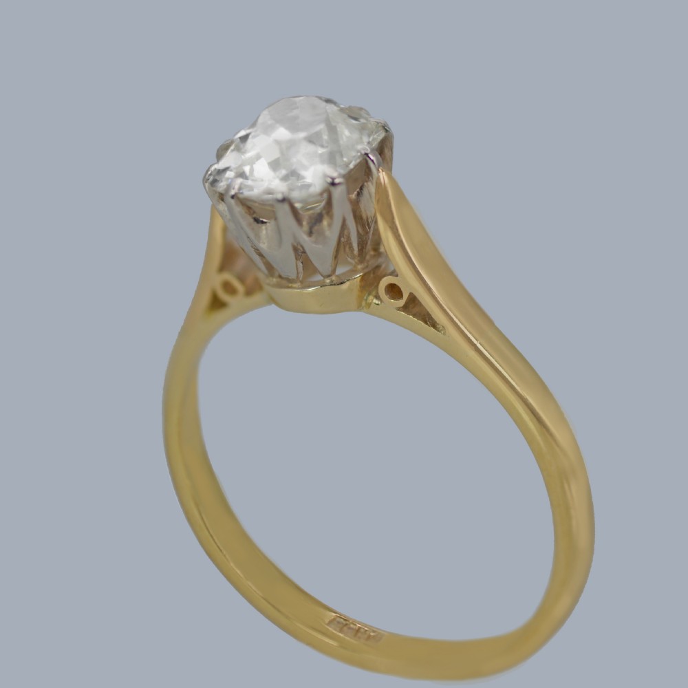 A vintage 18ct yellow gold solitaire ring featuring a 1.3-carat old cushion-cut diamond held in white metal claw settings. View IX