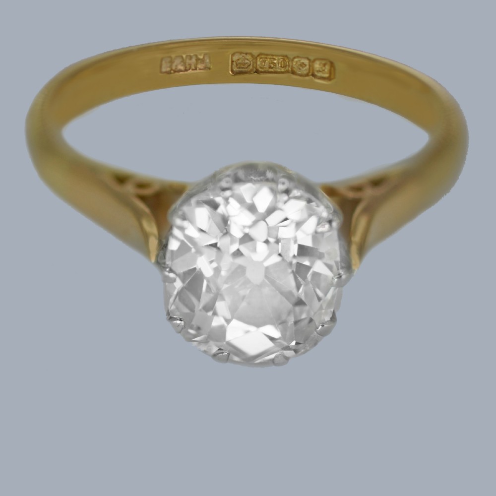 A vintage 18ct yellow gold solitaire ring featuring a 1.3-carat old cushion-cut diamond held in white metal claw settings. View X