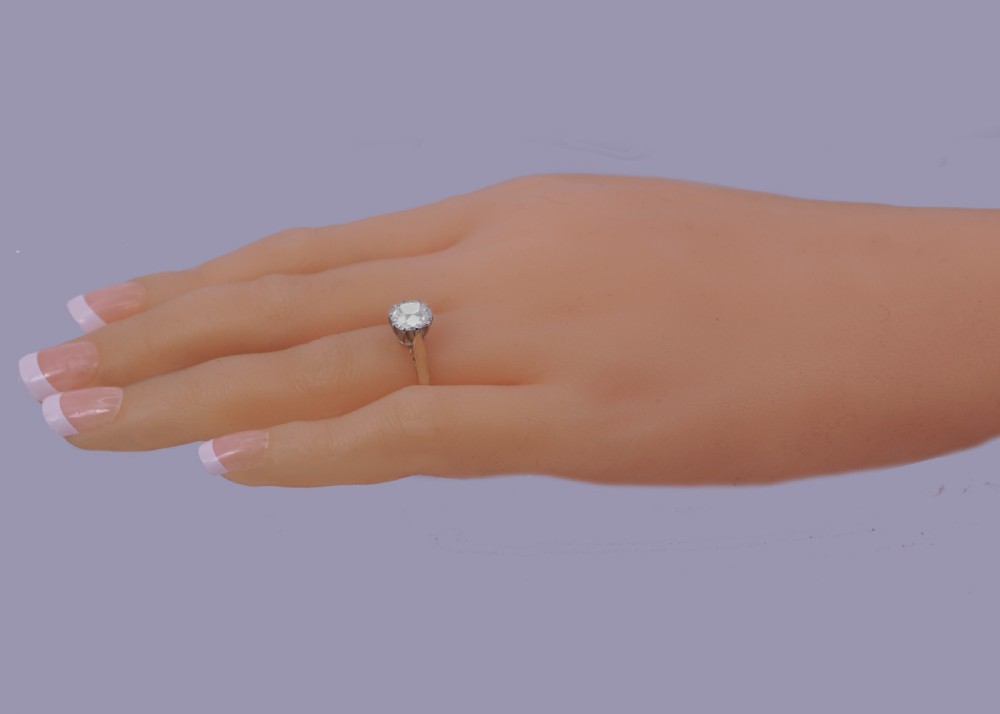A vintage 18ct yellow gold solitaire ring featuring a 1.3-carat old cushion-cut diamond held in white metal claw settings. View XIX
