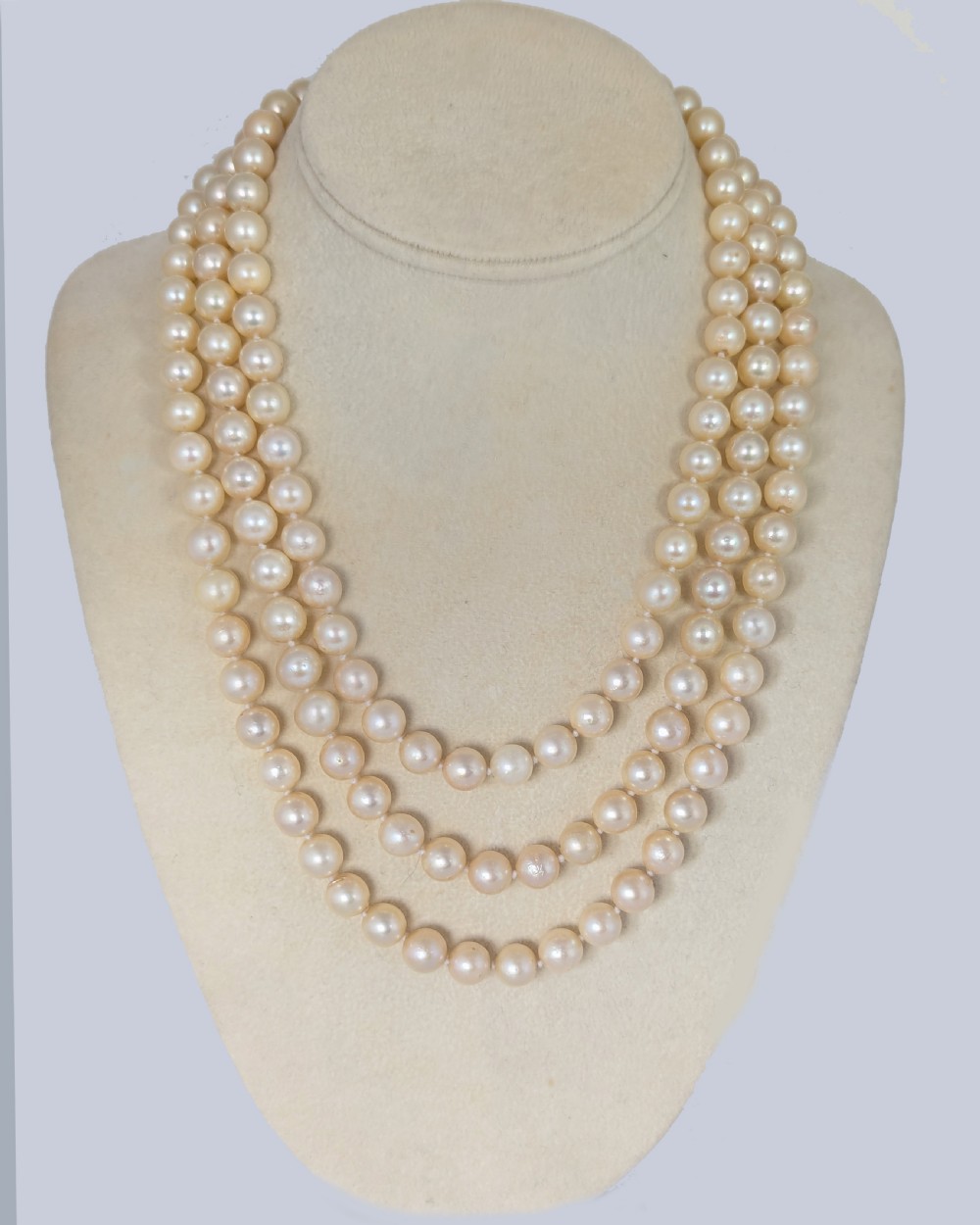 A long vintage cultured pearl sautoir necklace layered in multiple loops around a neck, featuring a small spherical gold clasp. View VIII