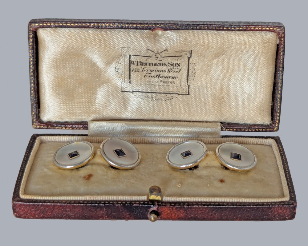 Four round double-sided cufflinks made from mother of pearl discs, each set with a central square blue sapphire framed in platinum and gold. View III