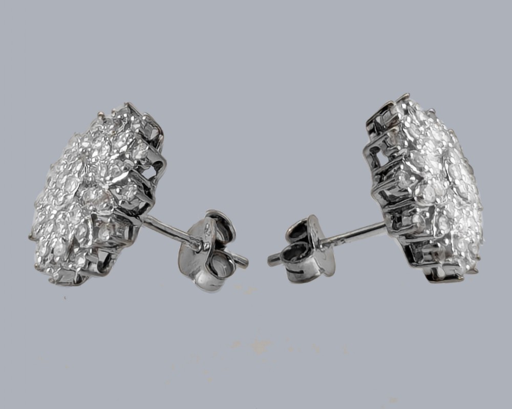A pair of sterling silver floral cluster stud earrings set with multiple single cut diamonds in concentric tiers. View VII
