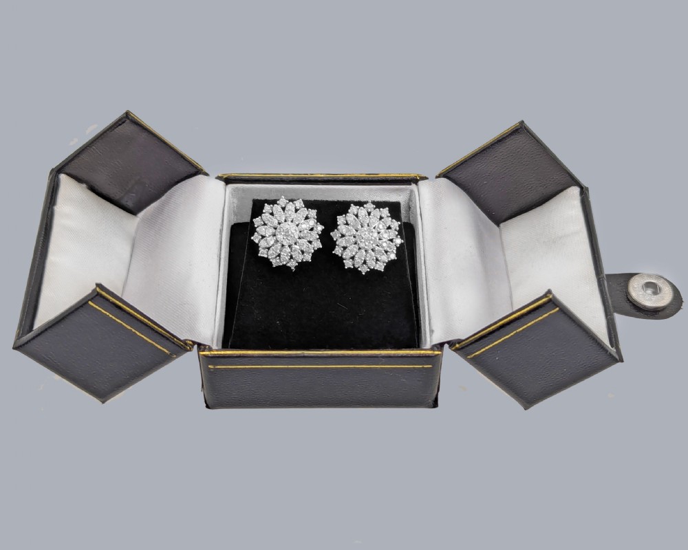 A pair of sterling silver floral cluster stud earrings set with multiple single cut diamonds in concentric tiers. View X