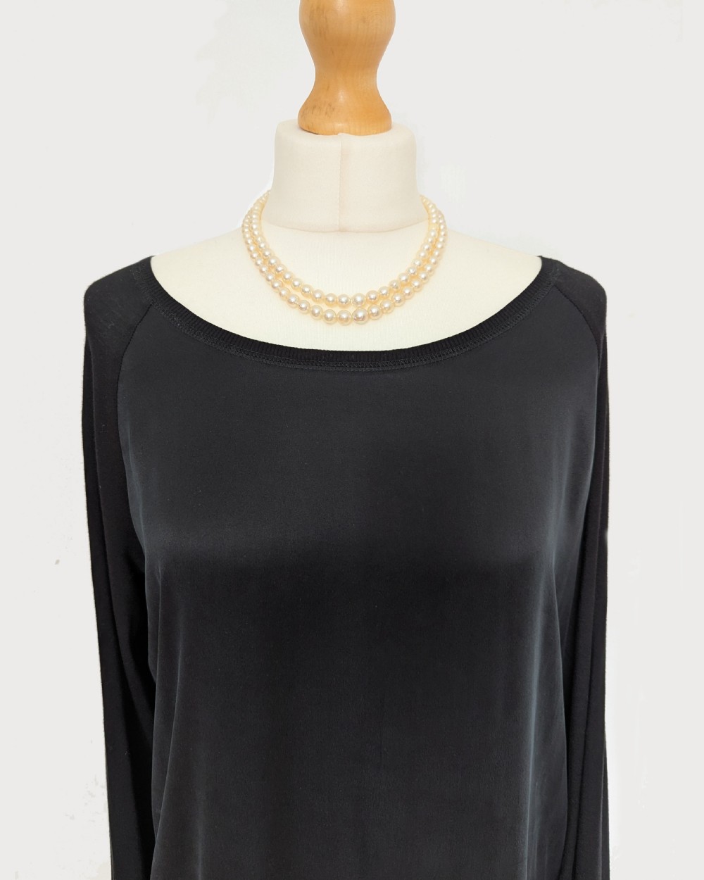 A 1950s double strand cultured pearl necklace with two rows of cream pearls linked by a circular 9ct gold clasp featuring a cabochon garnet. View VIII