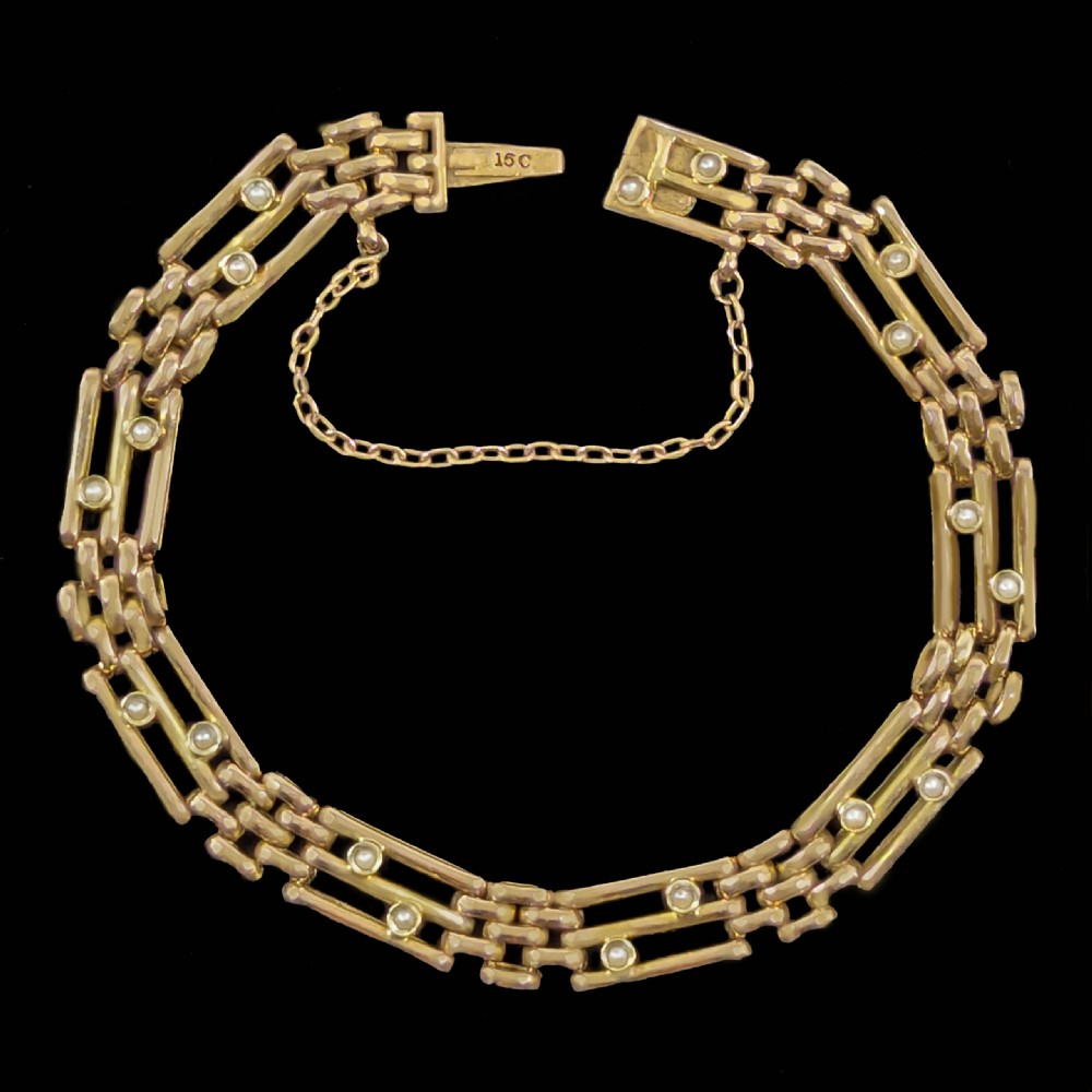 A circular Victorian 15ct yellow gold gate link bracelet set with split pearls and featuring a safety chain. View II