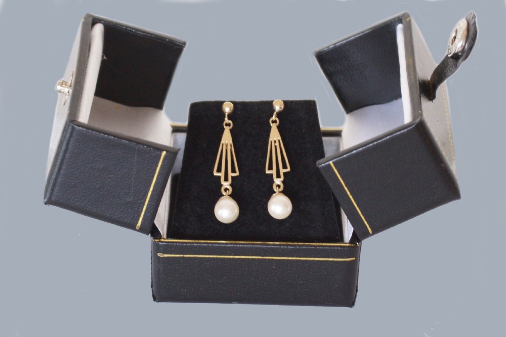 A pair of 9ct yellow gold drop earrings with geometric openwork triangular motifs suspending round cream pearls. View VI