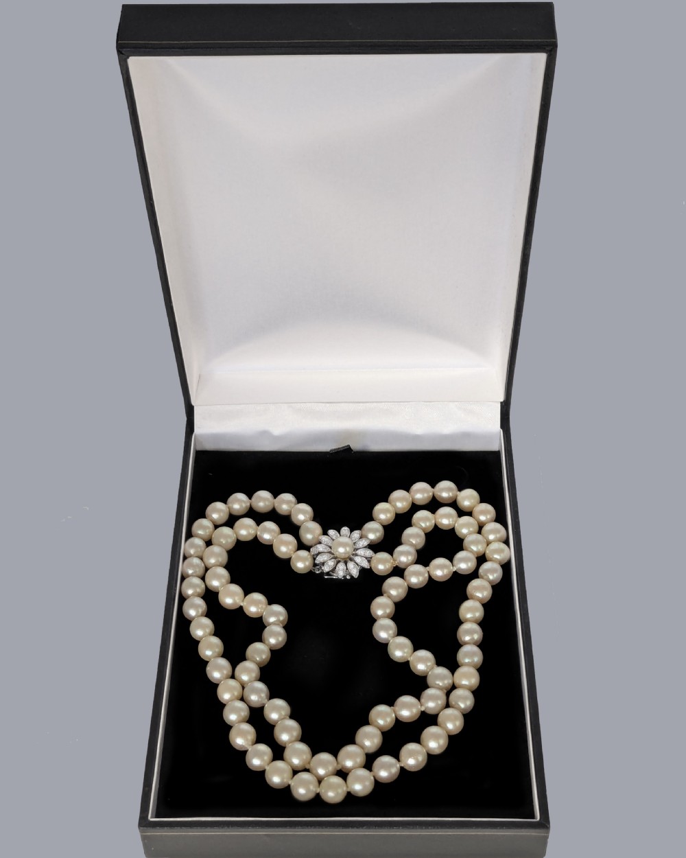 A double-strand choker necklace composed of cream-coloured pearls connected by a white gold floral daisy clasp set with diamonds. View VIII