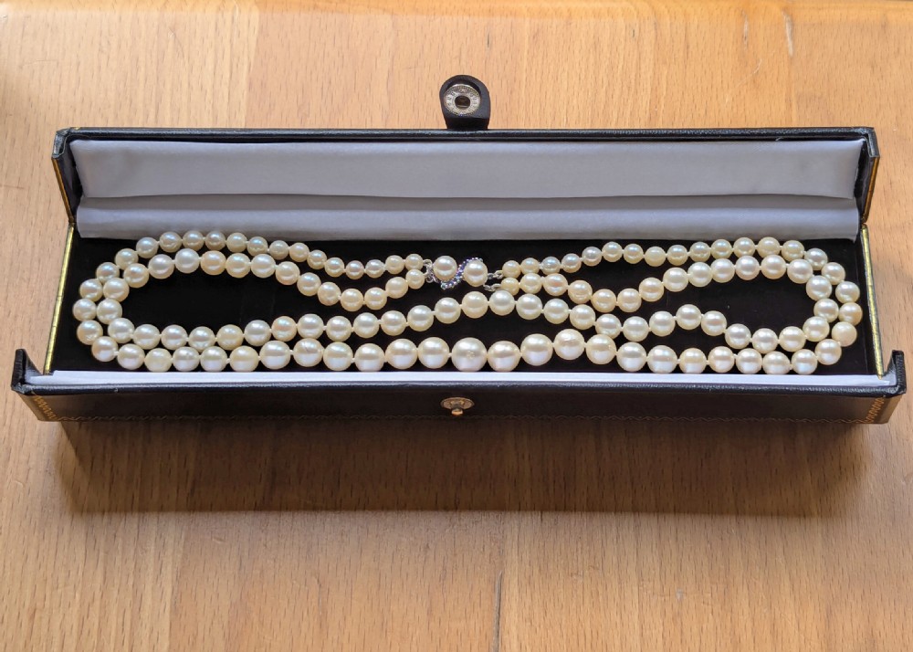 A double-strand cultured pearl necklace featuring uniform cream pearls arranged in two parallel rows with a sapphire-set gold clasp. View VIII