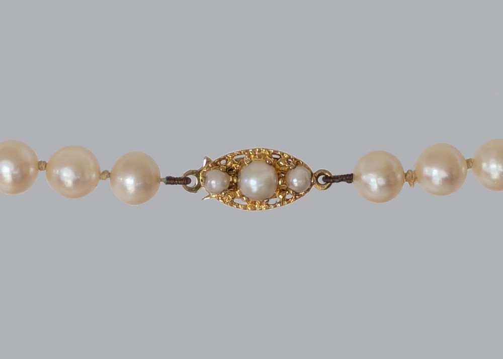 A long hand-knotted strand of cream cultured pearls featuring an oval filigree 9ct yellow gold clasp. View III