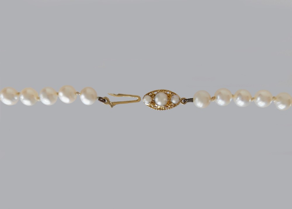A long hand-knotted strand of cream cultured pearls featuring an oval filigree 9ct yellow gold clasp. View V