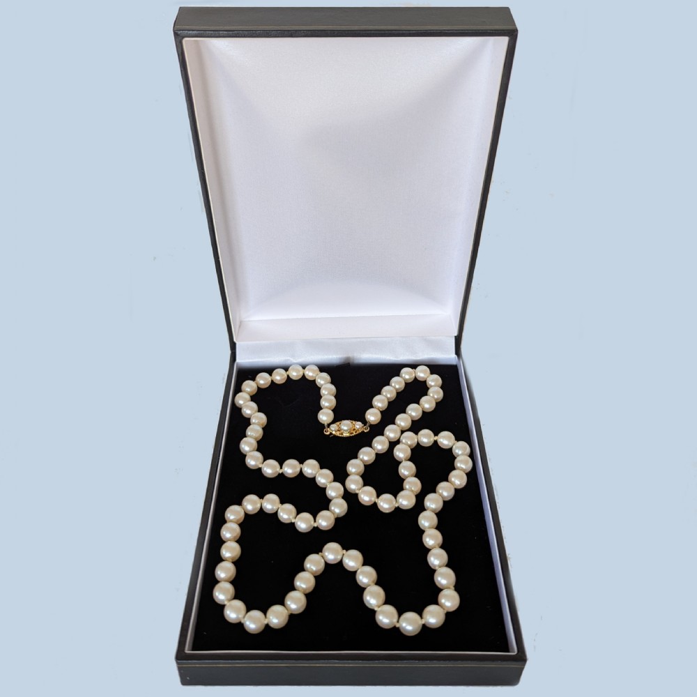 A long hand-knotted strand of cream cultured pearls featuring an oval filigree 9ct yellow gold clasp. View VI
