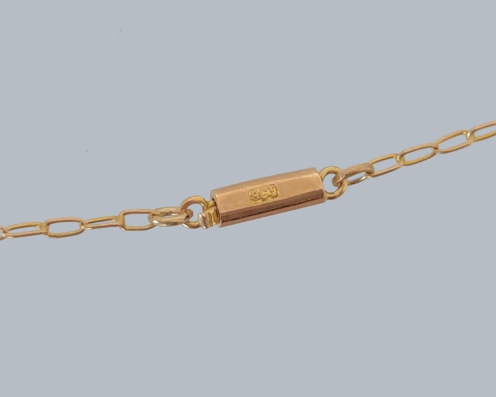 An Edwardian 9ct gold openwork pendant featuring set seed pearls in a foliate motif with two round purple amethysts, suspended from a gold chain. View III