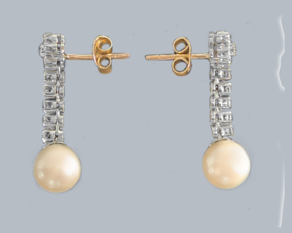 A pair of 1960s 18ct white gold drop earrings featuring floral diamond cluster tops above linear diamond links and round white pearls. View III