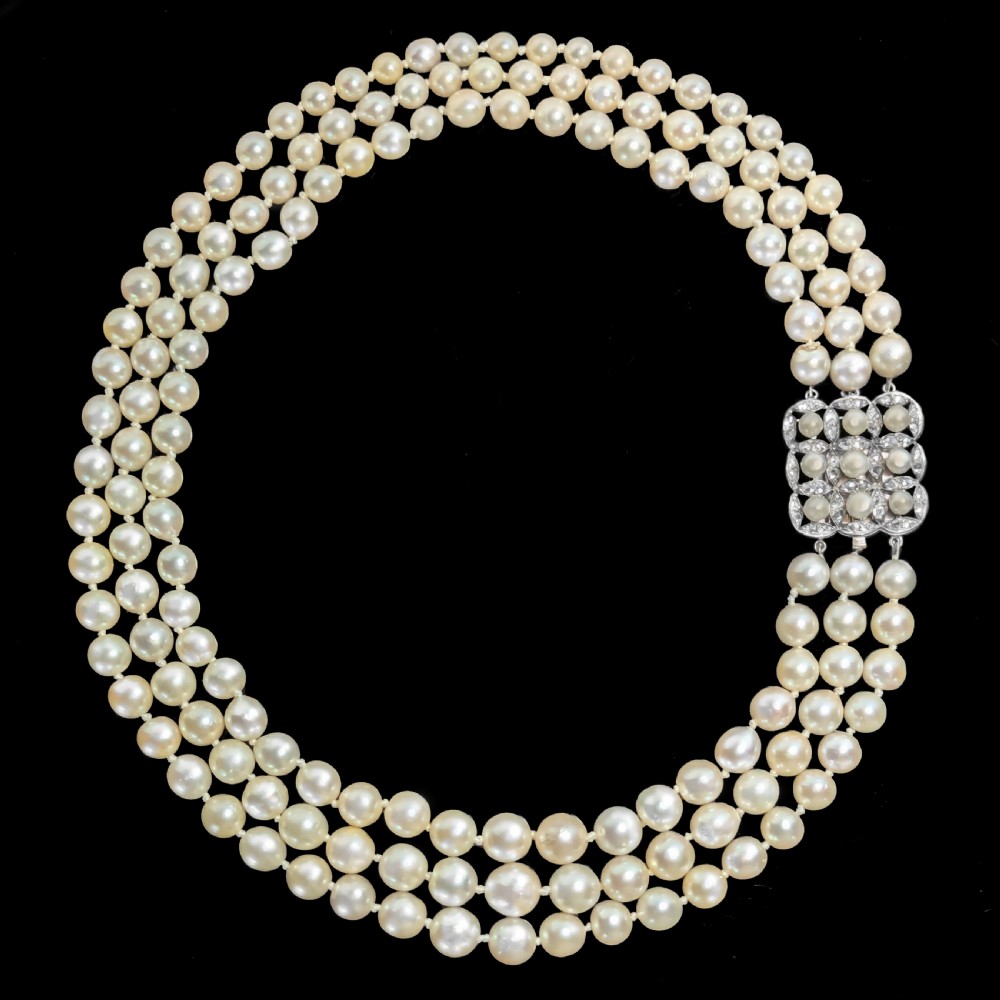 An Art Deco triple-strand cream pearl necklace featuring an ornate square clasp set with rose-cut diamonds and central pearl accents. View III