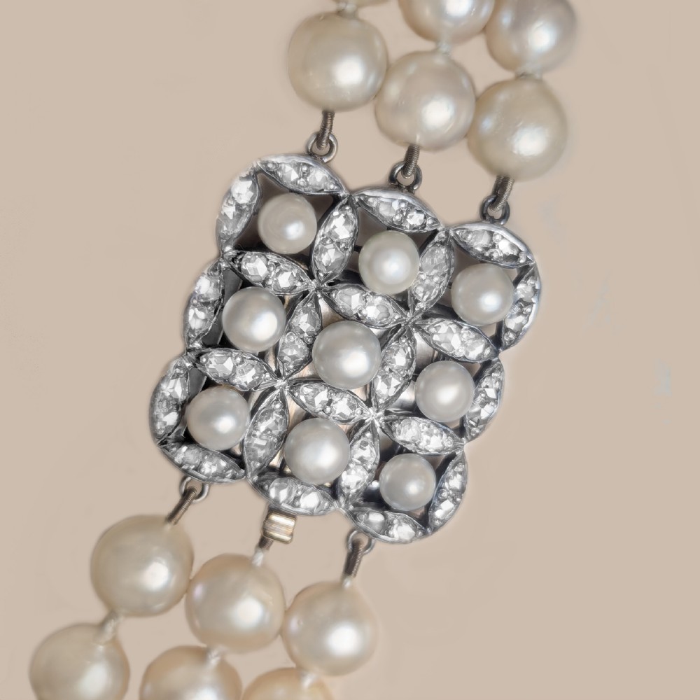 An Art Deco triple-strand cream pearl necklace featuring an ornate square clasp set with rose-cut diamonds and central pearl accents. View VIII