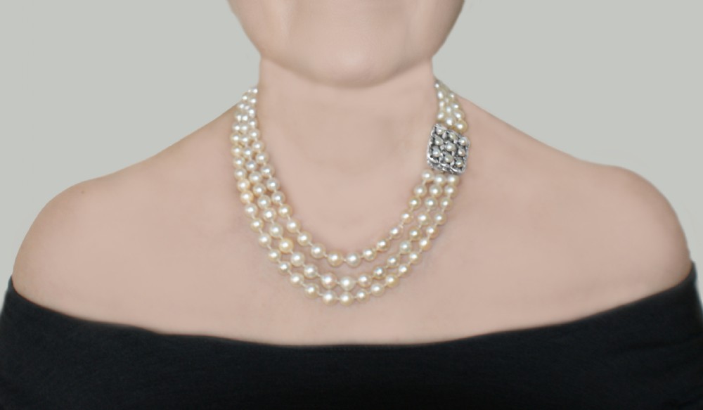 An Art Deco triple-strand cream pearl necklace featuring an ornate square clasp set with rose-cut diamonds and central pearl accents. View XI