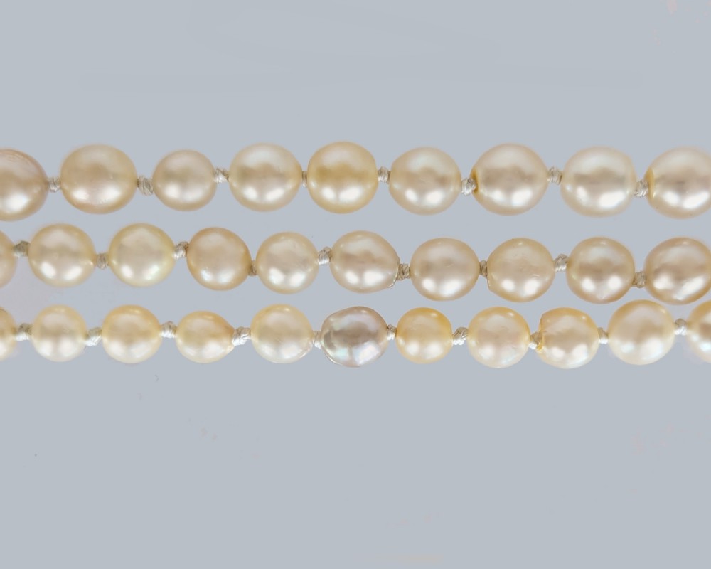 An Art Deco triple-strand cream pearl necklace featuring an ornate square clasp set with rose-cut diamonds and central pearl accents. View XXI