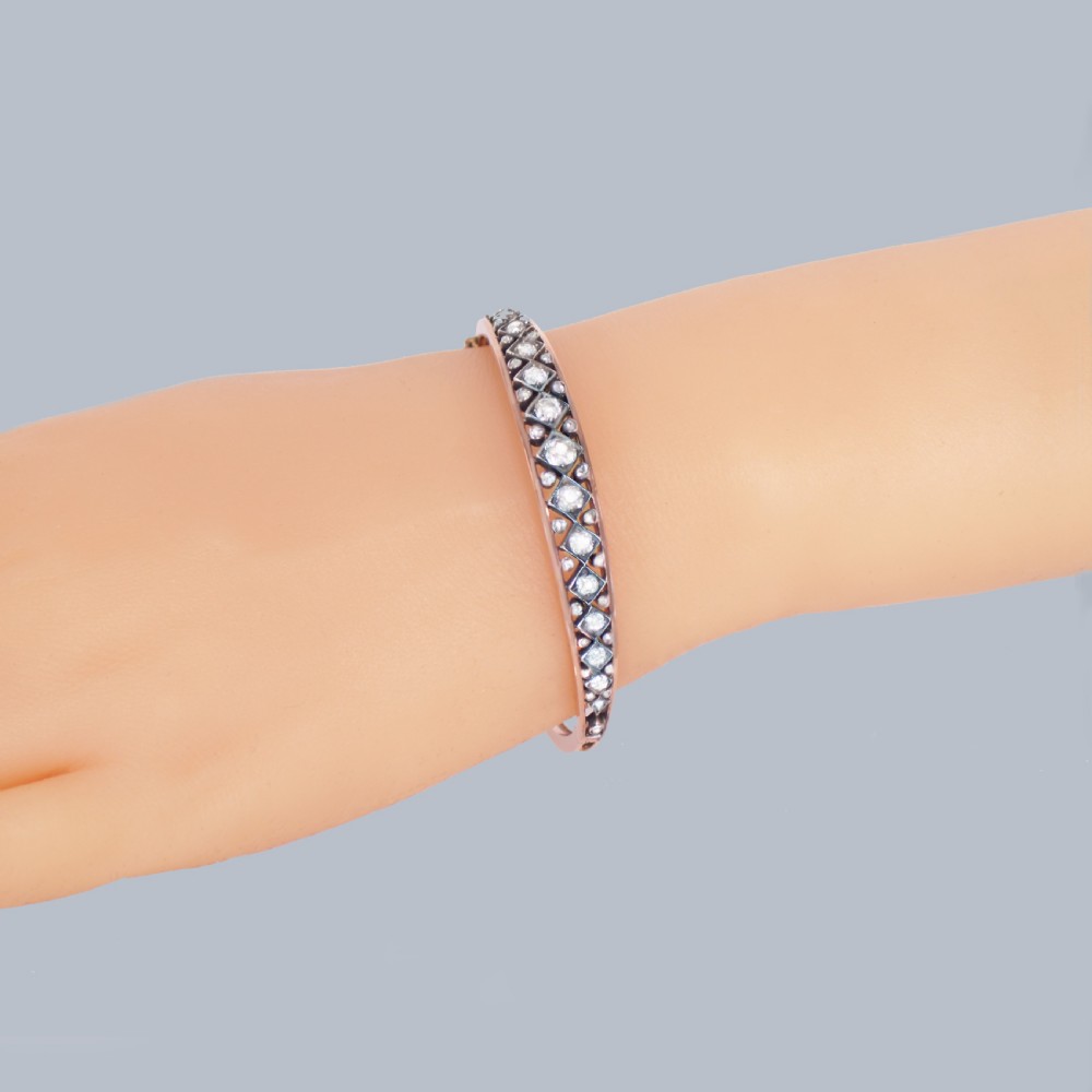 A Victorian 15ct gold and silver-topped hinged bangle set with a row of old mine cut diamonds in diamond-shaped mounts. View III
