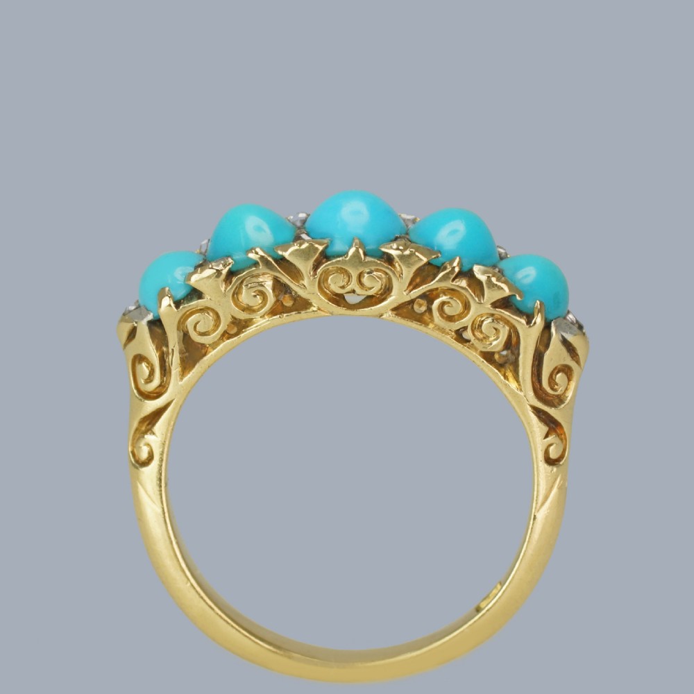 An 18ct yellow gold Victorian ring set with five graduated cabochon turquoise stones punctuated by small diamond points. View II