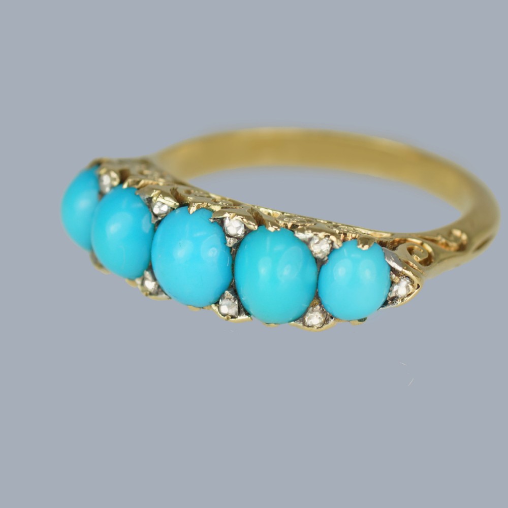 An 18ct yellow gold Victorian ring set with five graduated cabochon turquoise stones punctuated by small diamond points. View IV