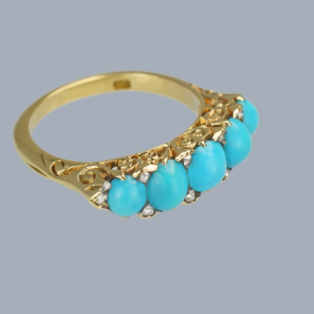 An 18ct yellow gold Victorian ring set with five graduated cabochon turquoise stones punctuated by small diamond points. View V