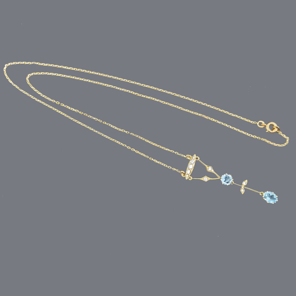 An Edwardian 9ct yellow gold lavalier drop necklace featuring two faceted light blue aquamarines suspended from an openwork bar set with accent diamonds. View II